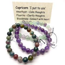 Load image into Gallery viewer, Set of 3 Star Sign stretch bracelets with semi precious gems | presented in a satin Pouch with descriptions of the stones  | Capricorn~ Amethyst, Fluorite, Bloodstone | Genuine Gems from Crystal Heart Australia since 1986 